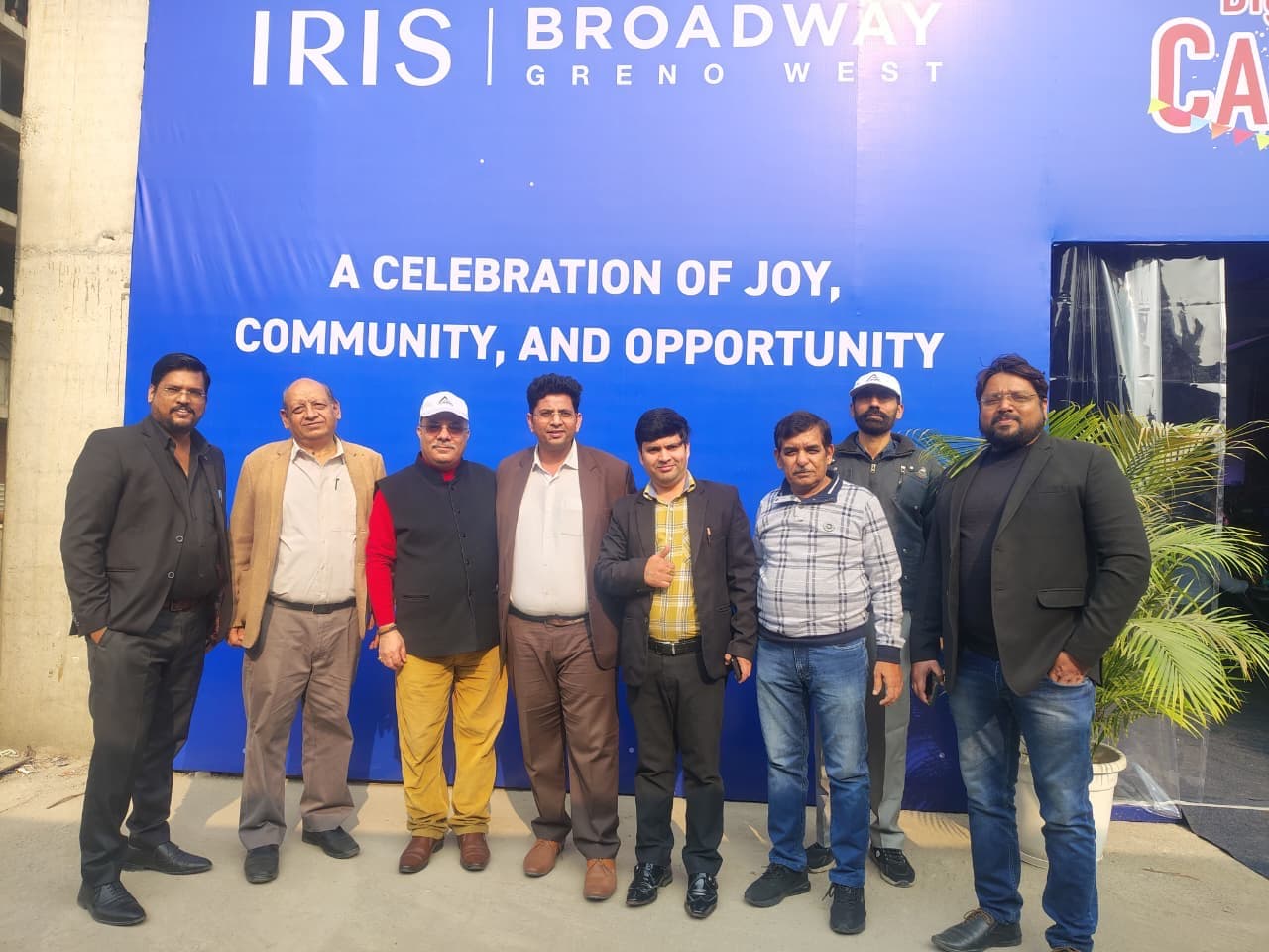 Partners in front of the IRIS Broadway Greno West carnival banner